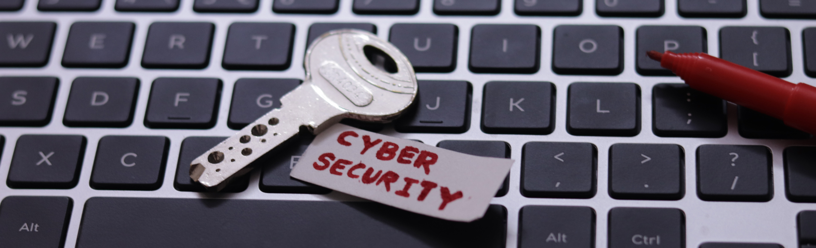 Key laid on top of laptop keyboard to represent Cyber Security
