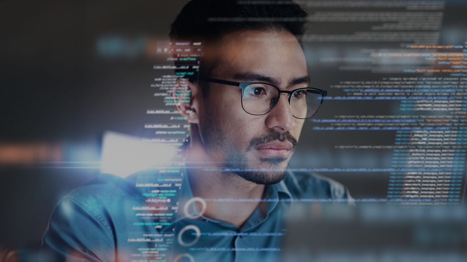 IT man looking at a screen with code snippets across the image